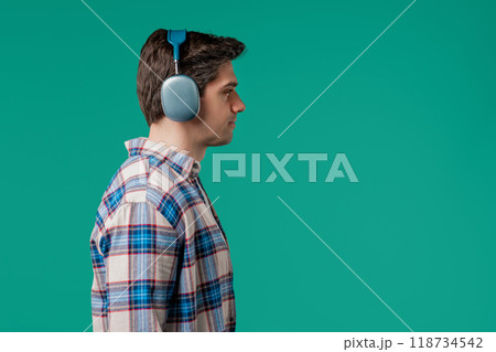 Positive handsome man listening music,enjoying with modern headphones,copy space Positive handsome man listening music,enjoying with modern headphones,copy space 118734542