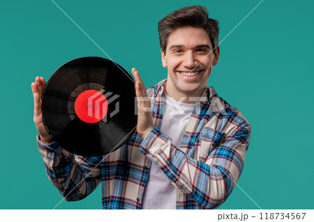 Handsome man dancing vinyl record disc on blue. Hobby, music lover, collection Handsome man dancing vinyl record disc on blue. Hobby, music lover, collection 118734567