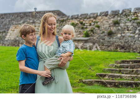 Mother with her toddler and teenage sons exploring Fuerte de San Felipe de Bacalar. Family travel, cultural heritage, and historical adventure concept Mother with her toddler and teenage sons exploring Fuerte de San Felipe de Bacalar. Family travel, cultural heritage, and historical adventure concept 118736896