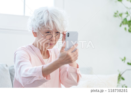 スマホを見る老眼のシニア女性 118738281