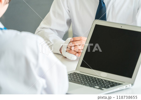 指を怪我して医師に診察してもらう中年男性患者 118738655