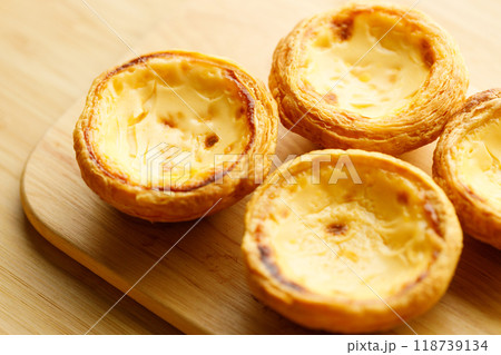 Stack of Portuguese sweet dessert egg tart or Pastel de Nata on wooden board on wooden table.  Selective focus. 118739134