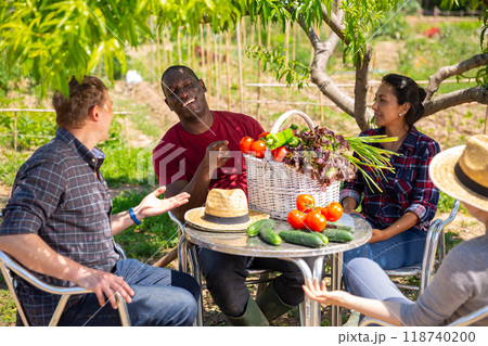 Good friends have conversation at table in backyard of village house 118740200