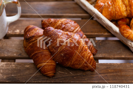 Several twisted croissants with stuffing lie against background of simple wooden table. 118740431