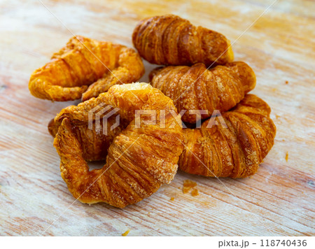 Several twisted croissants with stuffing lie against background of simple wooden table. Several twisted croissants with stuffing lie against background of simple wooden table. 118740436