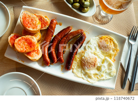 Fried eggs served with chistorra sausages 118740672