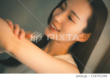 若い女性の夜の二の腕スキンケア 若い女性の夜の二の腕スキンケア 118741206