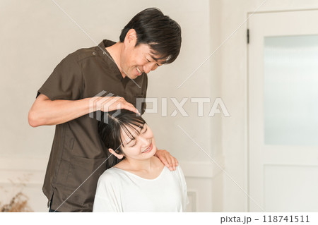 首こり・肩こりの施術をする整体院・整骨院・マッサージに通う女性と整体師・セラピスト 首こり・肩こりの施術をする整体院・整骨院・マッサージに通う女性と整体師・セラピスト 118741511