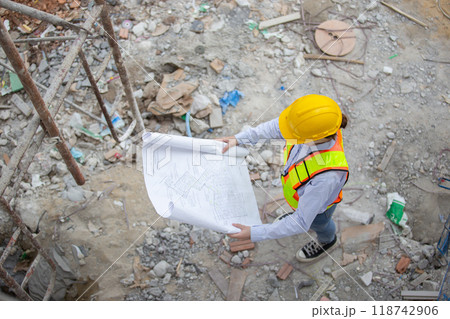 Female worker with blueprint working standing in construction site. Female worker with blueprint working standing in construction site. 118742906
