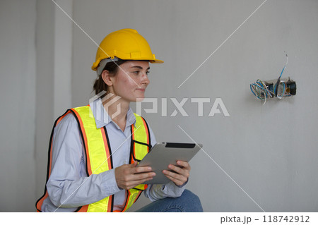 Construction civil engineer woman using tablet checking quality Manage electrical system office 118742912