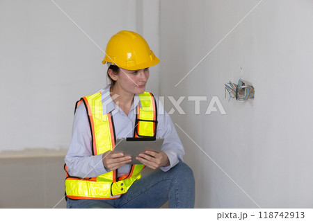 Construction civil engineer woman using tablet checking quality Manage electrical system office 118742913