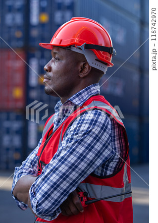 portrait of Male African American smiling engineering in uniform wear hard hat standing containers portrait of Male African American smiling engineering in uniform wear hard hat standing containers 118742970