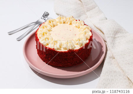 Red velvet cake on pink plate and towel on white background Red velvet cake on pink plate and towel on white background 118743116