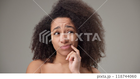 Beauty and healthcare - beautiful African American woman with curly afro hairstyle and clear, healthy skin looking around with doubt and distrust, thinking through choices or options 118744060