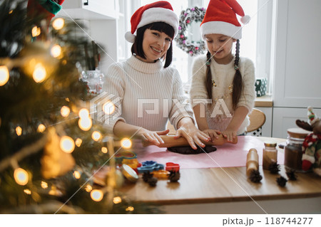 Mother and daughter baking cookies during Christmas holiday Mother and daughter baking cookies during Christmas holiday 118744277