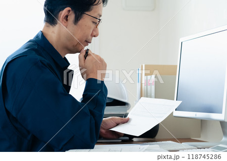 書類をチェックする作業服の男性 書類をチェックする作業服の男性 118745286