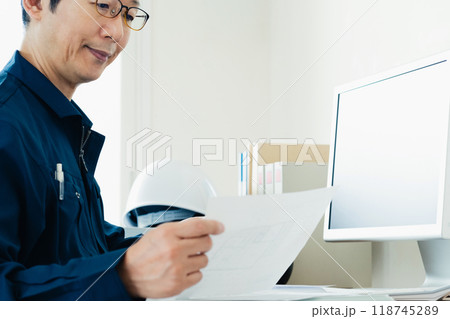 書類をチェックする作業服の男性 118745289