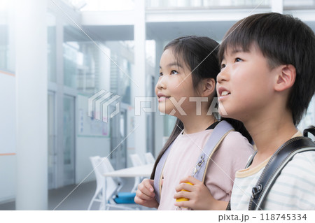 ランドセルを背負う小学生女子と男子が校舎を見上げるクローズアップ　横顔 118745334