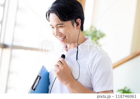 ワイヤレスマイクをつけて働く男性介護士 118746061