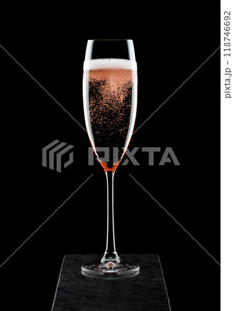 Elegant glass of pink rose champagne with bubbles on blavk marble board on black background. 118746692