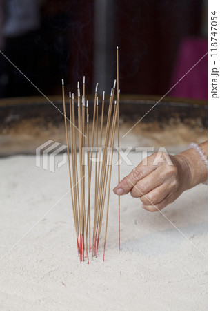 Woman adding an encent stick to an encent burner Woman adding an encent stick to an encent burner 118747054