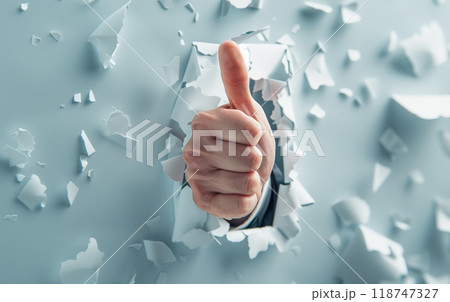 Thumbs up hand gesture breaking through a wall, symbolizing success, approval, and achievement in a creative and dynamic visual. Thumbs up hand gesture breaking through a wall, symbolizing success, approval, and achievement in a creative and dynamic visual. 118747327