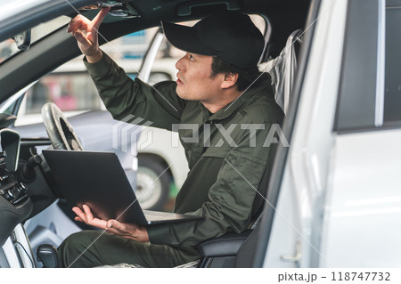 自動車の車内でノートパソコンを使う自動車整備士の男性 自動車の車内でノートパソコンを使う自動車整備士の男性 118747732