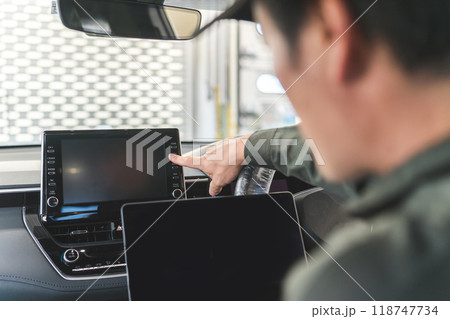 自動車の車内でノートパソコンを使う自動車整備士の男性 自動車の車内でノートパソコンを使う自動車整備士の男性 118747734