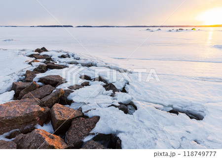 Landscape with frozen Baltic sea on a sunset. Cracked ice Landscape with frozen Baltic sea on a sunset. Cracked ice 118749777