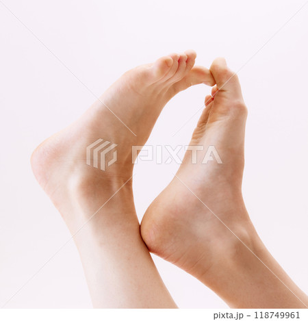 Cropped close-up image of female feet isolated on white studio background Cropped close-up image of female feet isolated on white studio background 118749961