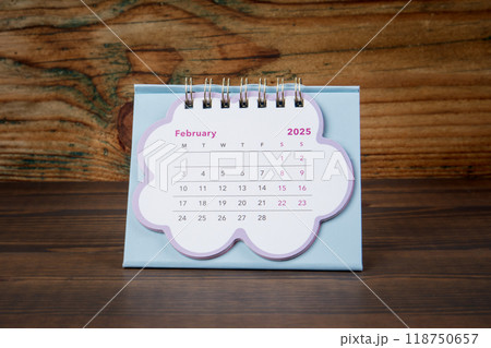 FEBRUARY 2025. cardboard desk calendar on a wooden texture background 118750657