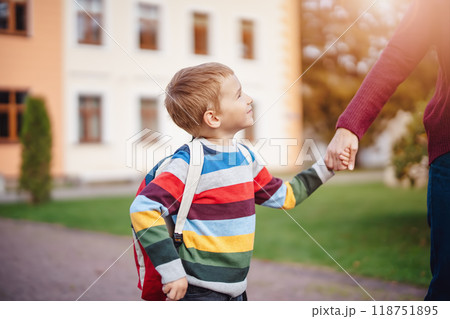 Mother takes her child to educational institution. Mother takes her child to educational institution. 118751895
