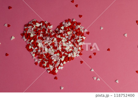 red, white and pink heart-shaped candies scattered on red paper red, white and pink heart-shaped candies scattered on red paper 118752400