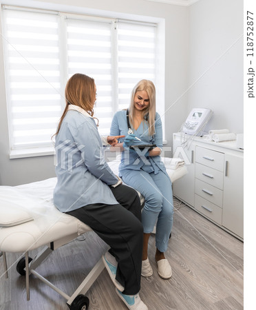 Health journey: The photo captures a woman's medical visit, during which the doctor details the prescribed procedures and sets the stage for a joint treatment plan. 118752877
