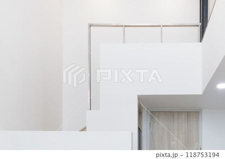sleek refrigerator fitted under a staircase, maximizing space in a minimalist, modern home. sleek refrigerator fitted under a staircase, maximizing space in a minimalist, modern home. 118753194