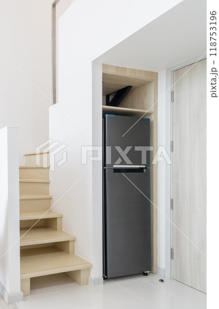 sleek refrigerator fitted under a staircase, maximizing space in a minimalist, modern home. sleek refrigerator fitted under a staircase, maximizing space in a minimalist, modern home. 118753196