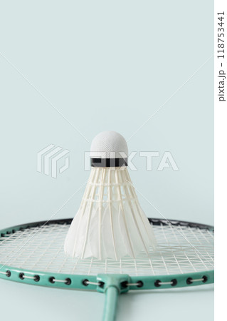 White badminton shuttlecock and badminton racket on blue background. Close up. Vertical format. Concept racket sport. Leisure games. 118753441