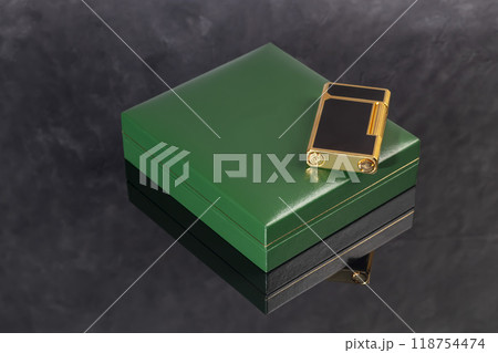 High quality lighter in a box on a dark background. Office interior. High quality lighter in a box on a dark background. Office interior. 118754474