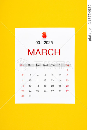 March 2025 calendar page with push pin on yellow background. March 2025 calendar page with push pin on yellow background. 118754929