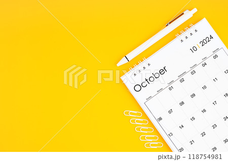 October 2024, Monthly desk calendar for 2024 year and pen with paper clips on yellow color background. 118754981