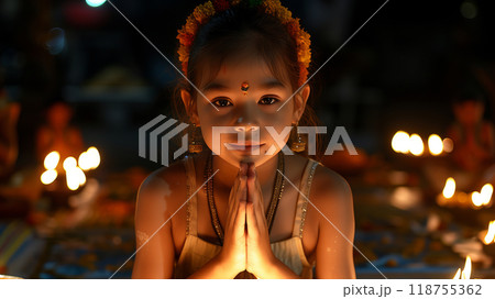 A Young Girl Offers Prayers During a Festival Celebration at Night With Candle Lights 118755362