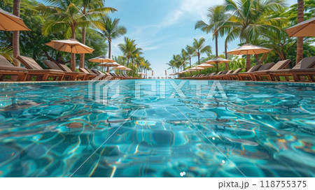 A Serene Pool Area Surrounded by Palm Trees Under a Clear Blue Sky at a Tropical Resort 118755375