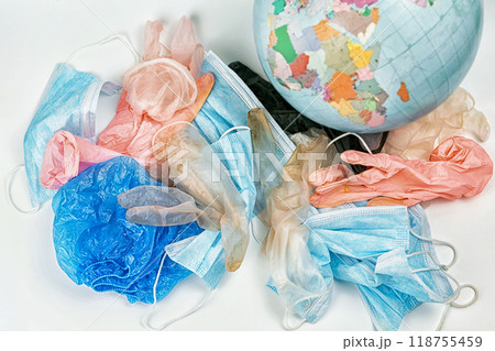 used gloves, medical masks and shoe covers on a globe background. The problem of ecology used gloves, medical masks and shoe covers on a globe background. The problem of ecology 118755459