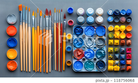 Artistic Arrangement of Paint Tubes, Brushes, and Palettes on a Gray Surface for Creative Projects 118756068