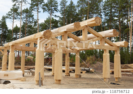 The construction site of a wooden house. Traditional log cabin built from wood logs. Cottage house design The construction site of a wooden house. Traditional log cabin built from wood logs. Cottage house design 118756712