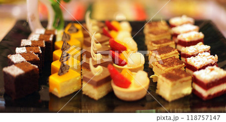 Beautiful multicolored decorated baked sweet tasty party cakes or catering cakes for party, bar dessert selection with cake, pie and pastries catering banquet, coffee break buffet at a conference 118757147