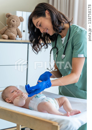 Female pediatrician checking reflexes of newborn baby at hospital Female pediatrician checking reflexes of newborn baby at hospital 118758178