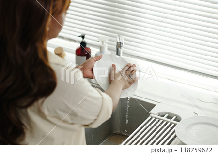 Washing Dishes at Kitchen Sink in Contemporary Environment 118759622