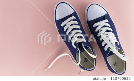 blue sports shoes with laces on a pink background, insulating blue sports shoes with laces on a pink background, insulating 118760620