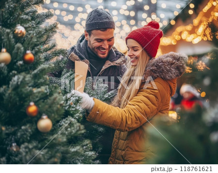 Couple Smiling In Front of Christmas Tree with Lights Couple Smiling In Front of Christmas Tree with Lights 118761621